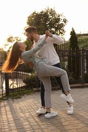 Lovely couple dancing together outdoors at sunset