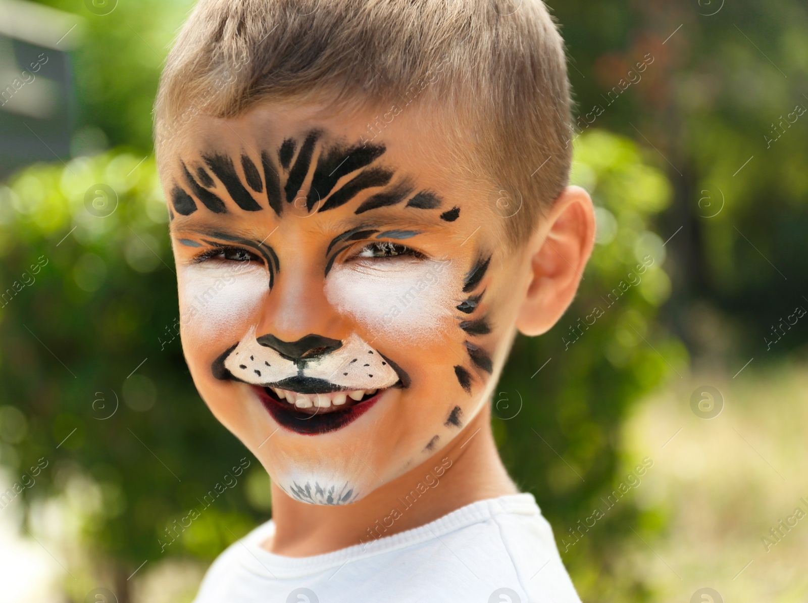 Photo of Cute little boy with face painting outdoors