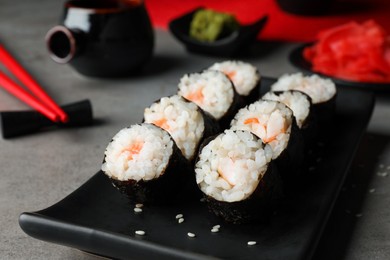 Photo of Tasty sushi rolls served on grey table, closeup