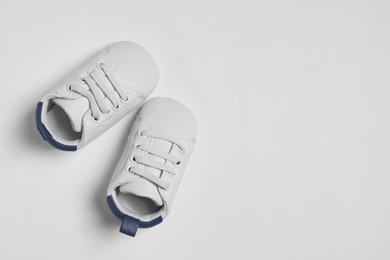 Photo of Cute baby shoes on white background, flat lay. Space for text