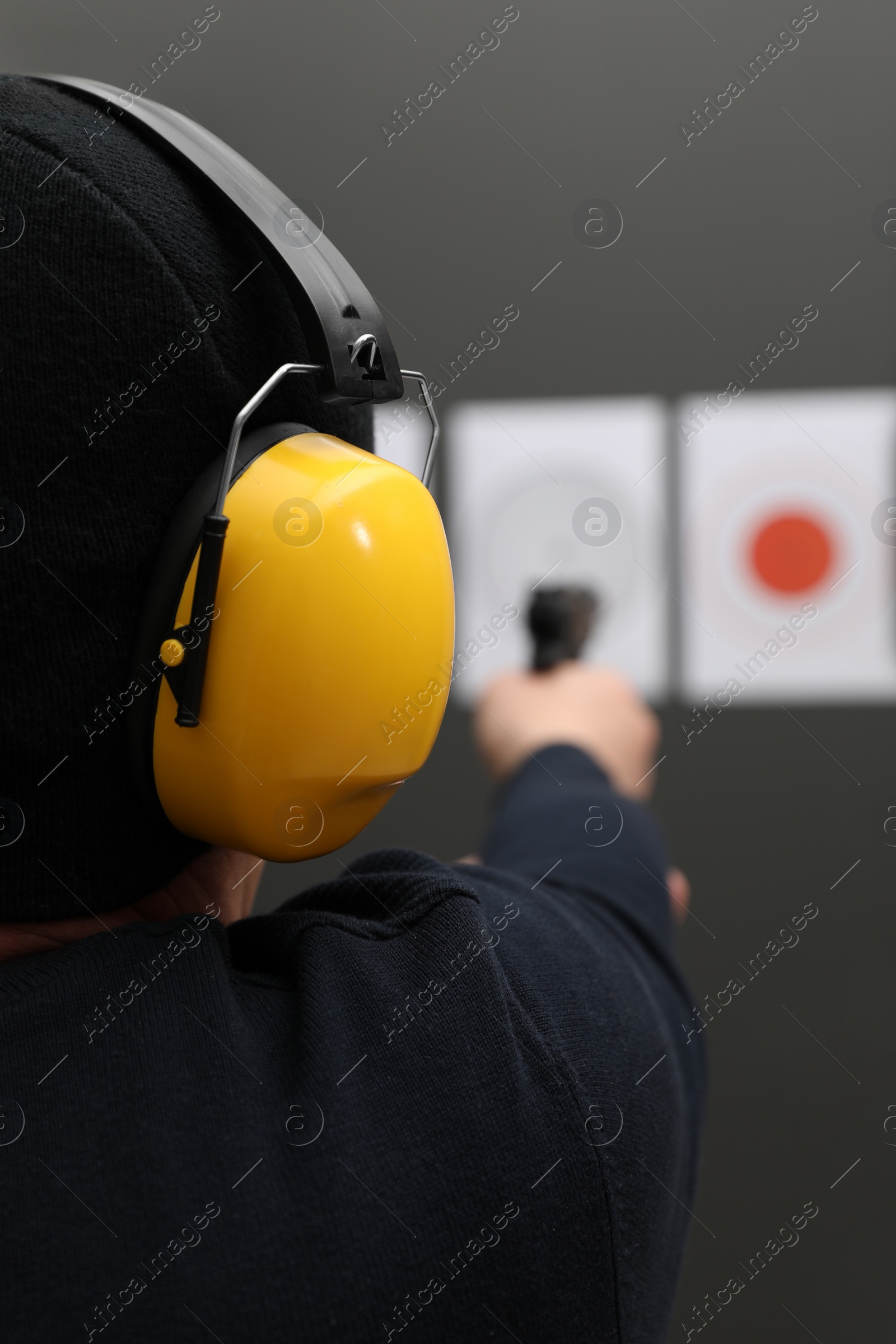 Photo of Man aiming at shooting target indoors, closeup