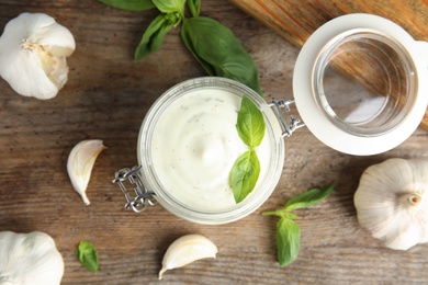 Photo of Flat lay composition with garlic sauce on wooden background