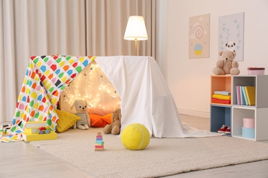 Play tent decorated with festive lights in modern child's room
