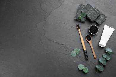 Flat lay composition with bamboo toothbrush on black stone table. Space for text