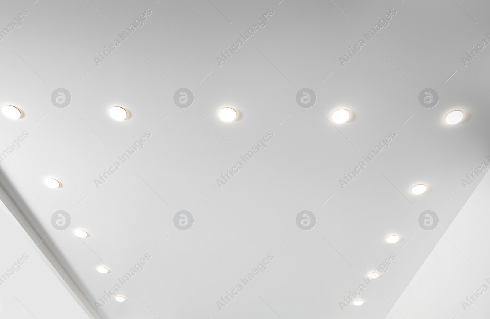 Photo of White ceiling with spot lamps in room, low angle view