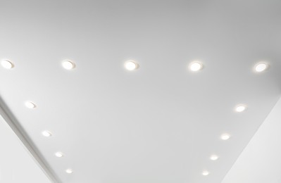 Photo of White ceiling with spot lamps in room, low angle view