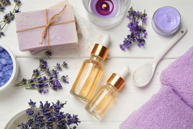 Photo of Flat lay composition with essential oil and lavender flowers on white wooden background