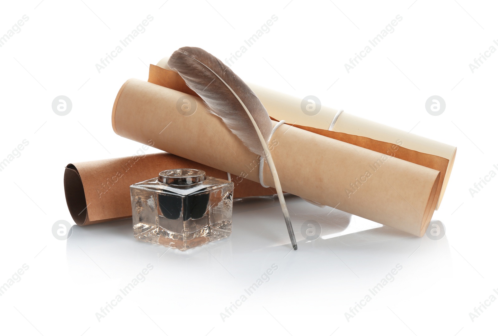 Photo of Feather pen with inkwell and paper scroll on white background