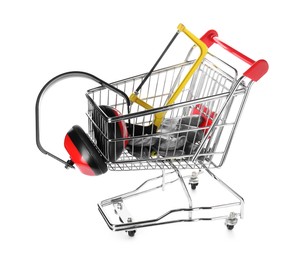 Photo of Small shopping cart with hacksaw, gloves and headphones isolated on white