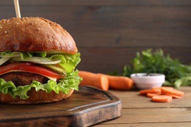 Photo of Delicious vegetarian burger served on wooden table, closeup