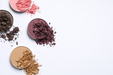 Different crushed eye shadows on white background, flat lay. Space for text