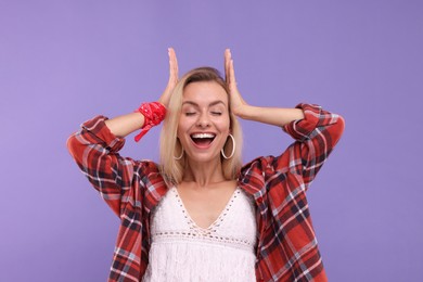 Photo of Portrait of excited hippie woman on purple background