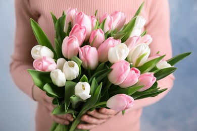 Photo of Woman holding bouquet of tulips, closeup view
