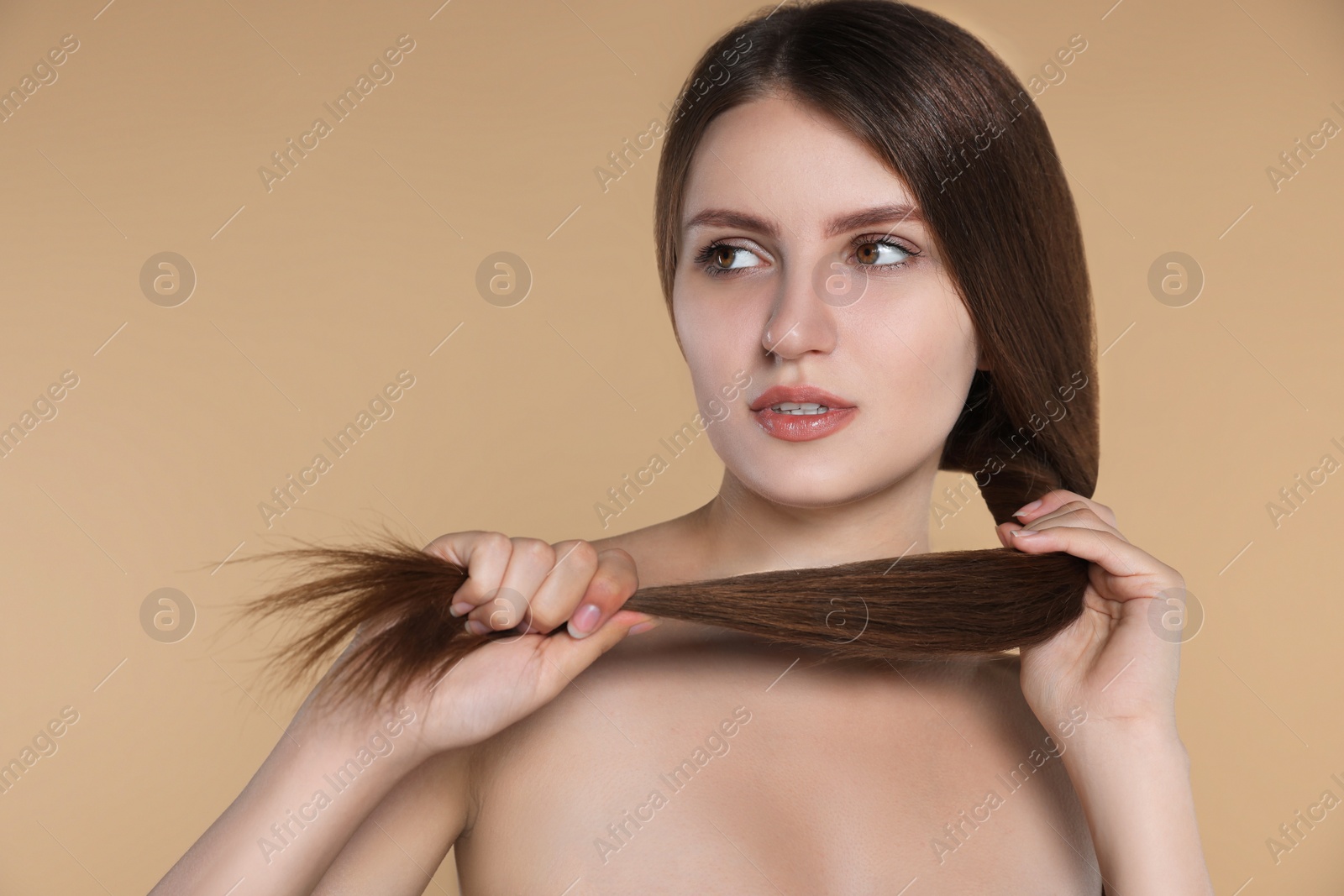 Photo of Young woman with strong healthy hair on beige background