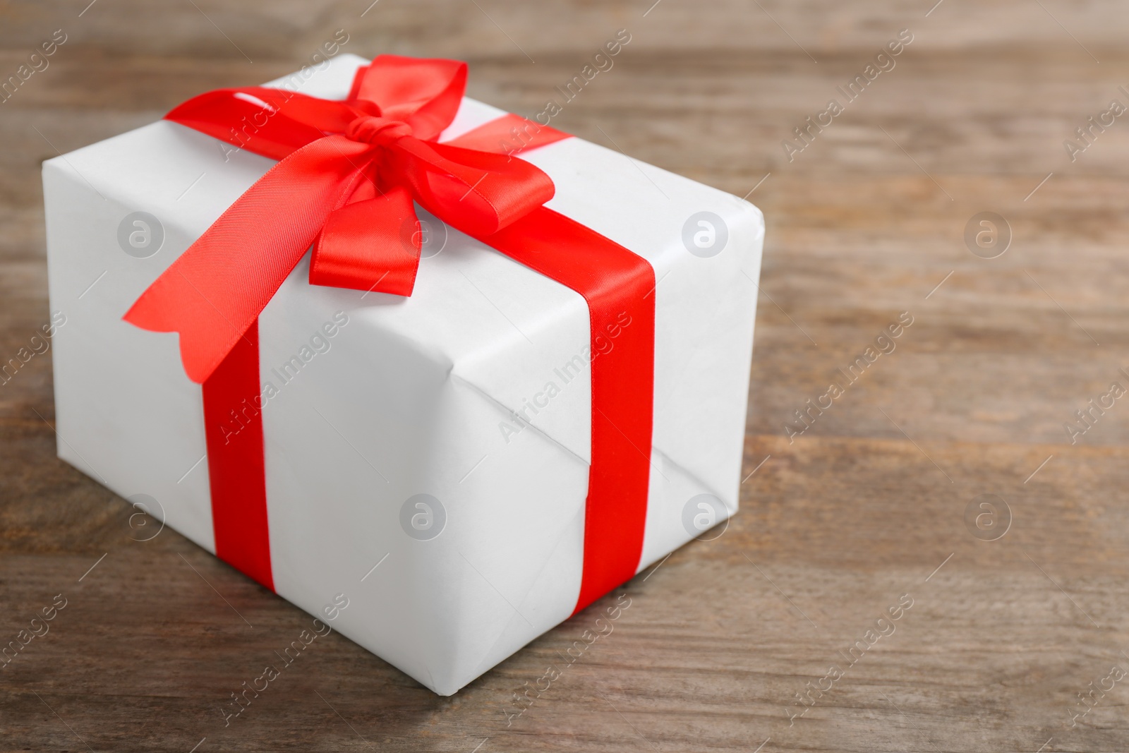 Photo of Elegant gift box with bow on wooden background