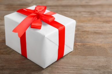 Photo of Elegant gift box with bow on wooden background