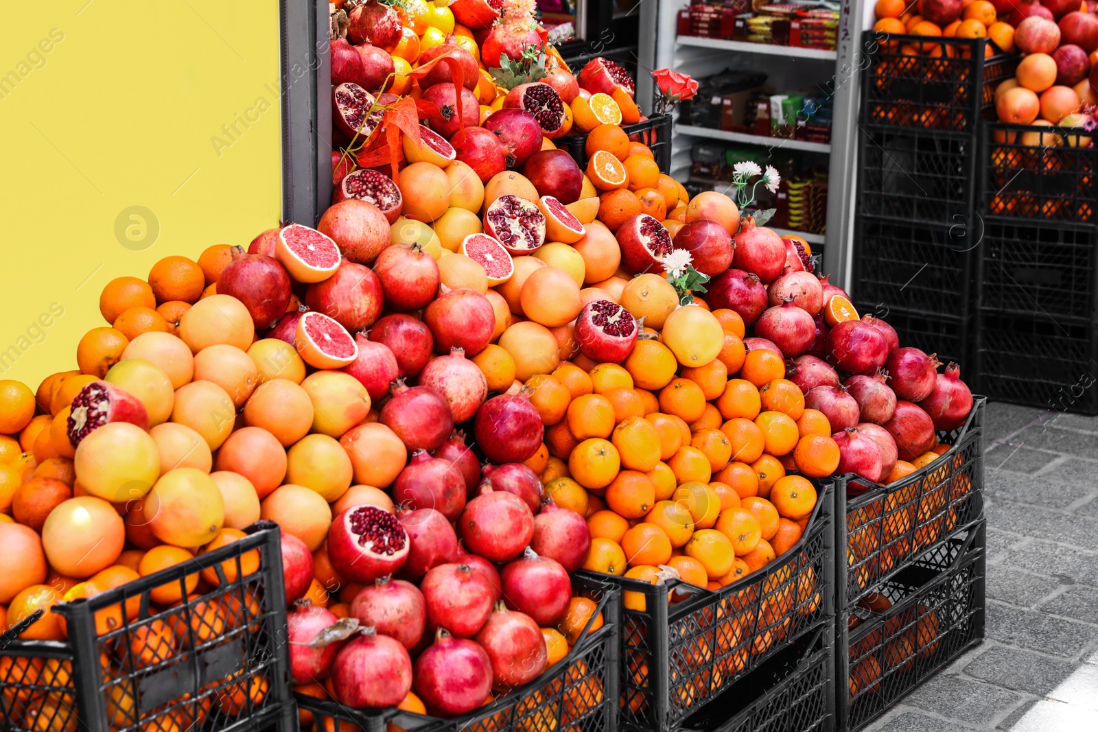 Photo of Crates with piles of different fresh fruits near shop outdoors