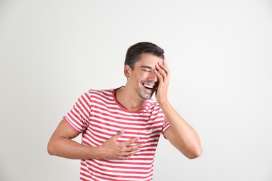 Photo of Portrait of handsome young man laughing on white background