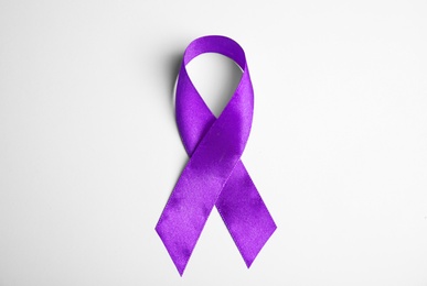 Purple ribbon on white background, top view. Domestic violence awareness