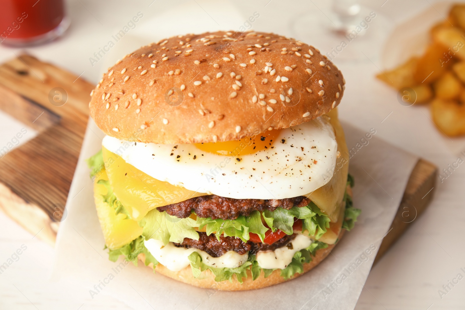 Photo of Tasty burger with fried egg on wooden board