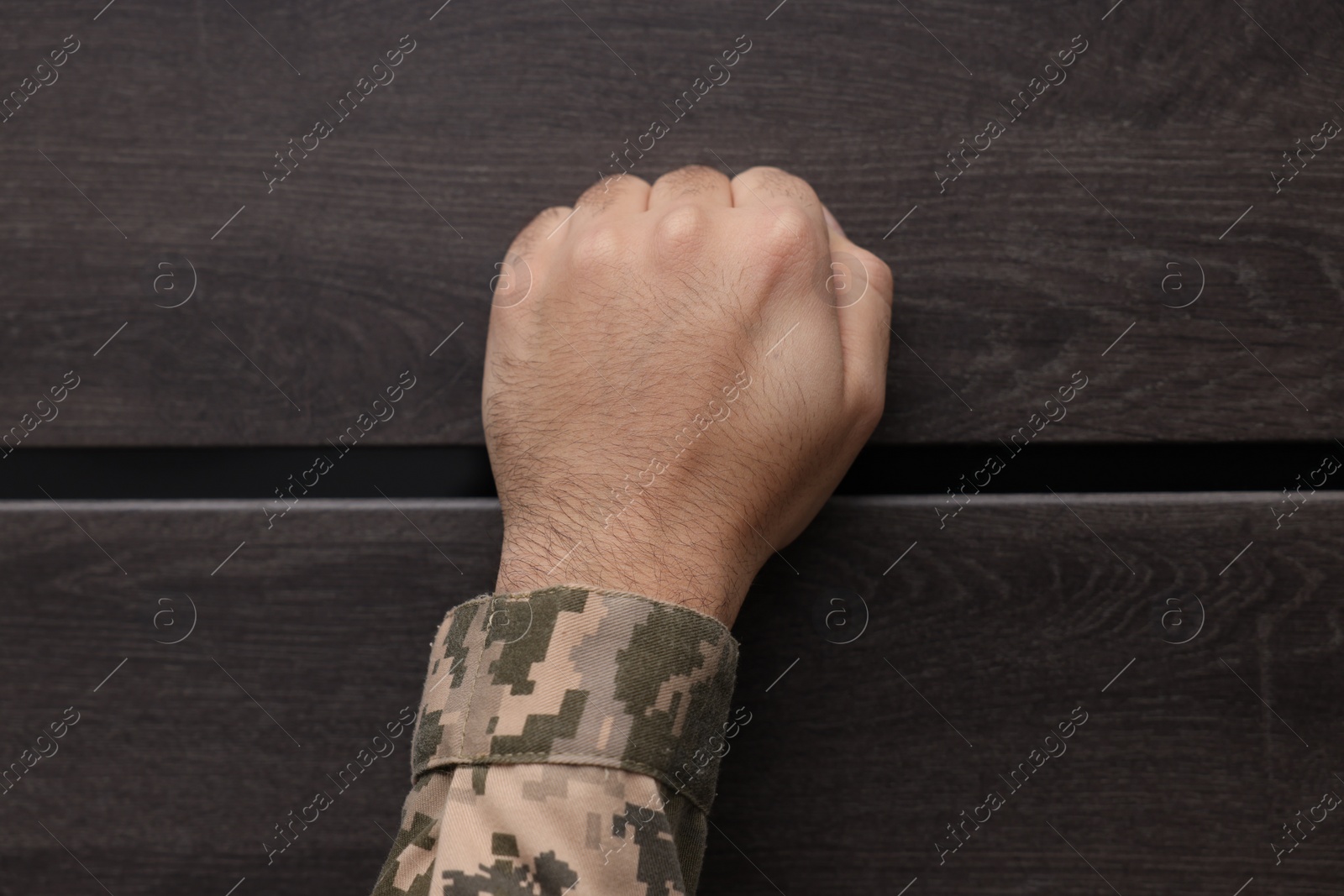 Photo of Military commissariat representative knocking on wooden door, closeup