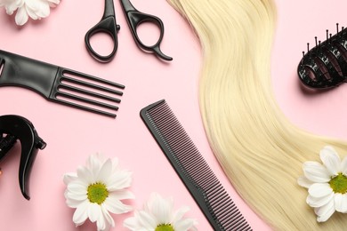 Photo of Flat lay composition with different hairdresser tools and flowers on pink background
