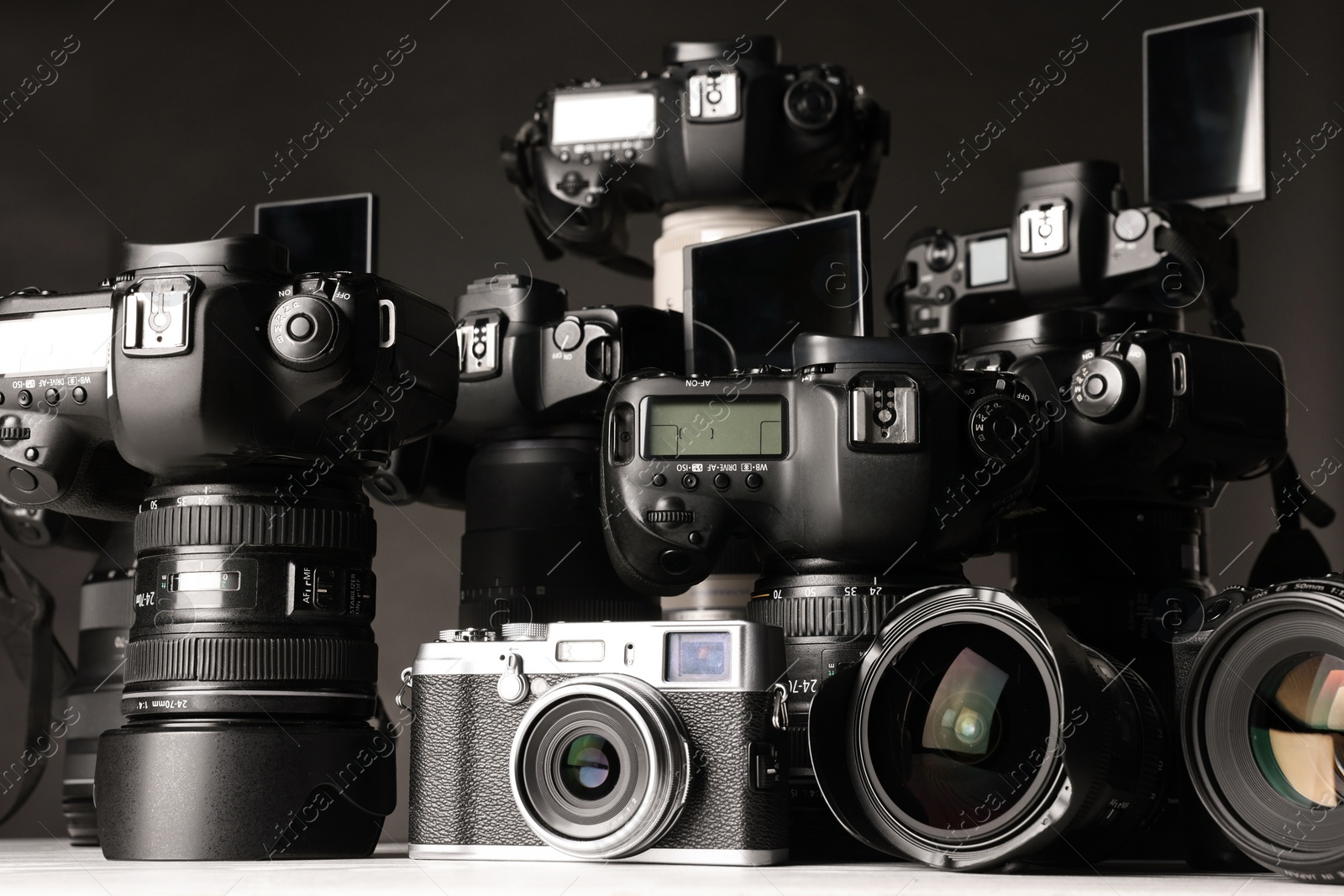 Photo of Modern cameras on white table, closeup. Professional photography equipment