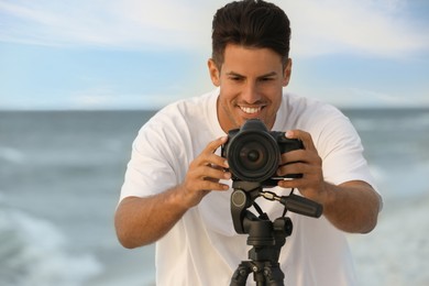 Photographer working with professional camera near sea