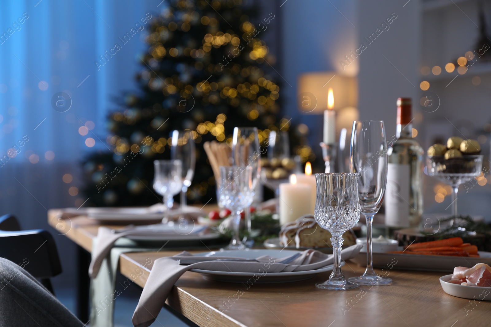 Photo of Christmas table setting with festive decor and dishware indoors