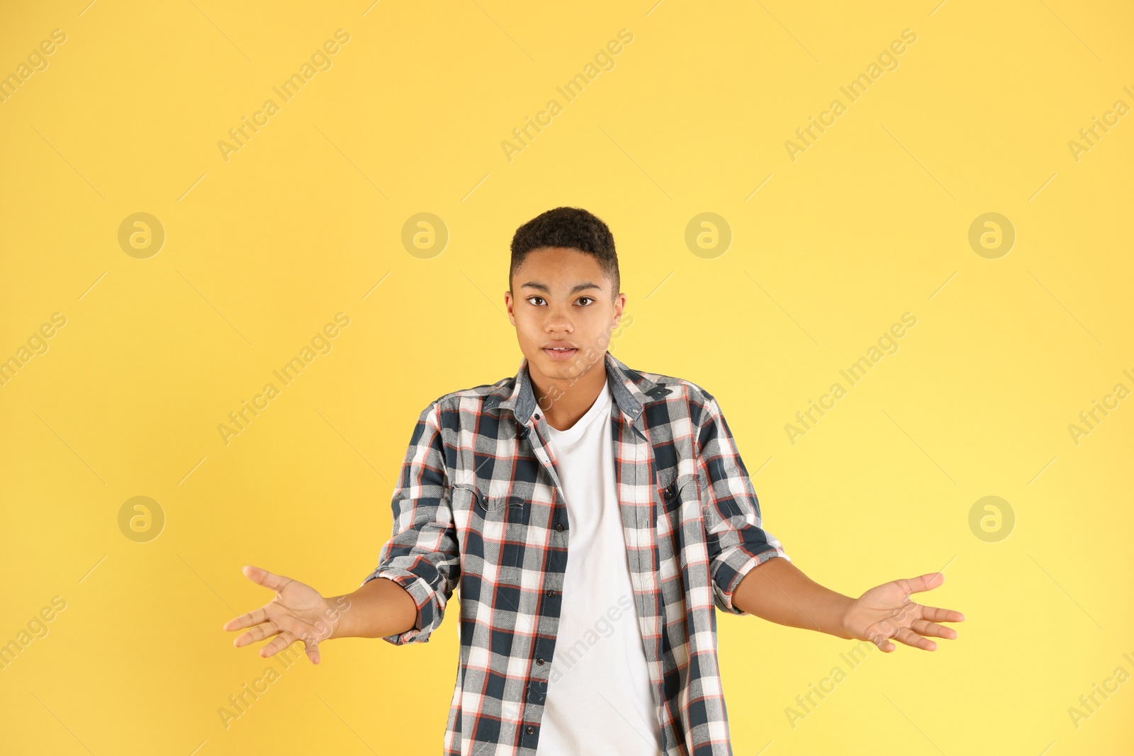 Photo of Portrait of emotional African-American teenage boy on color background