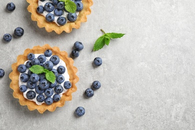 Delicious sweet pastries with berries on grey table, flat lay. Space for text