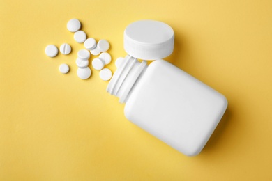 Photo of Bottle with different pills on color background, flat lay