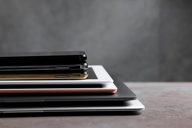 Photo of Many different modern gadgets on grey table. Space for text