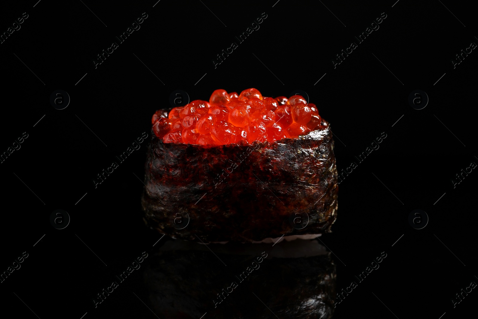Photo of Delicious sushi with red caviar on black background