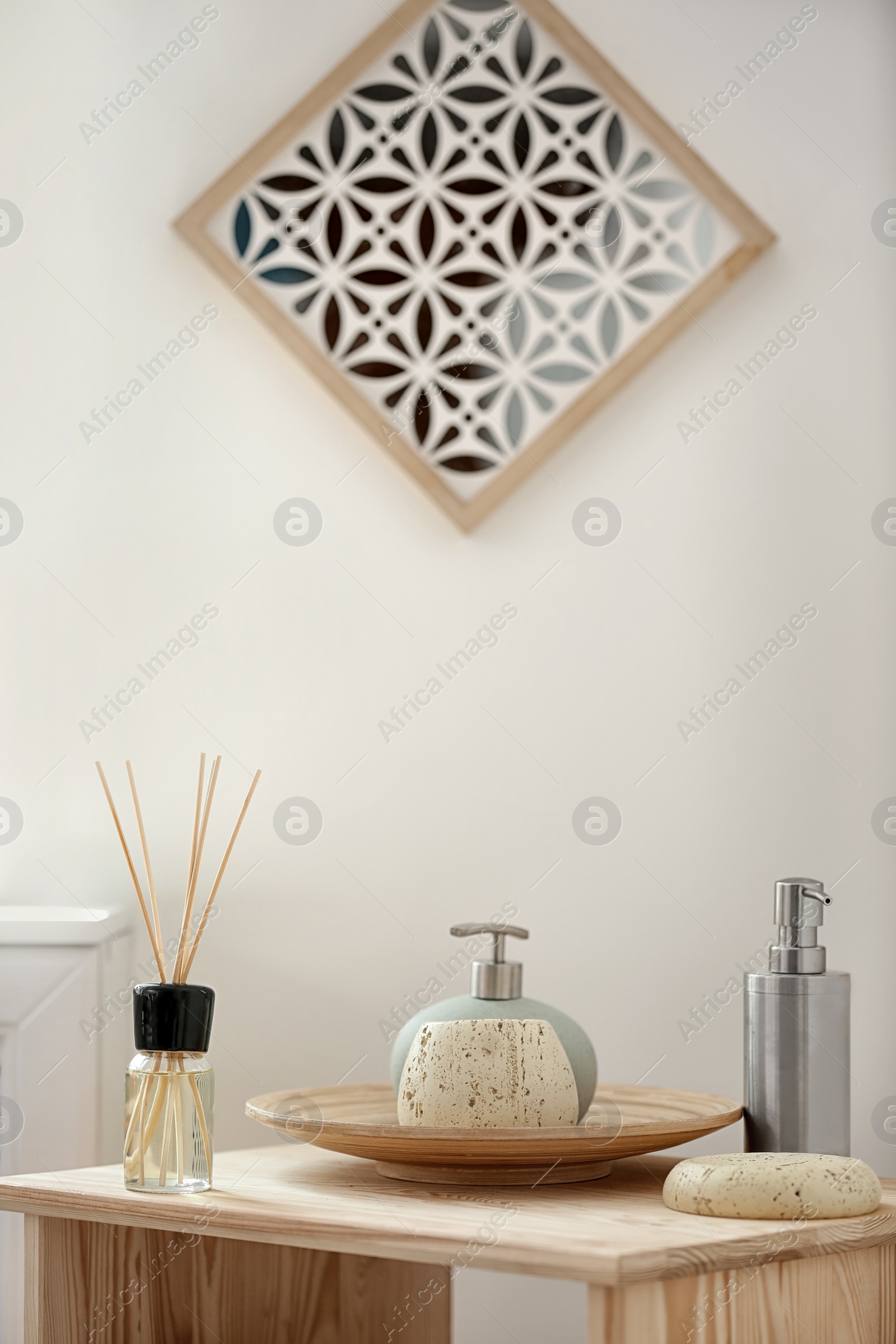 Photo of Aromatic reed air freshener and toiletries on table indoors