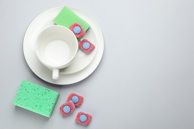 Photo of Flat lay composition with dishwasher detergent tablets on light background, space for text