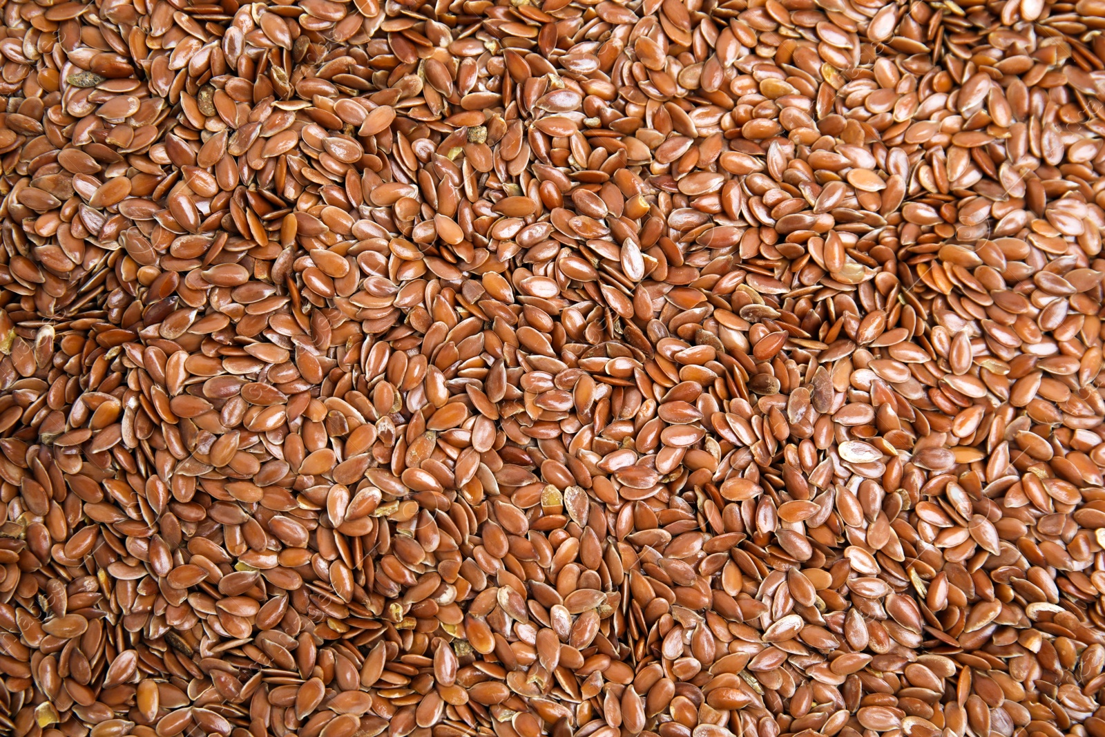 Photo of Heap of flax seeds as background, top view. Veggie food