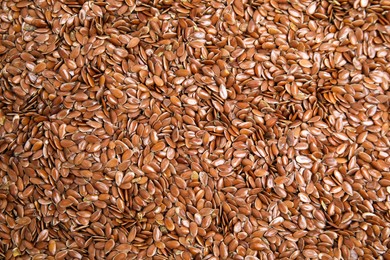 Photo of Heap of flax seeds as background, top view. Veggie food
