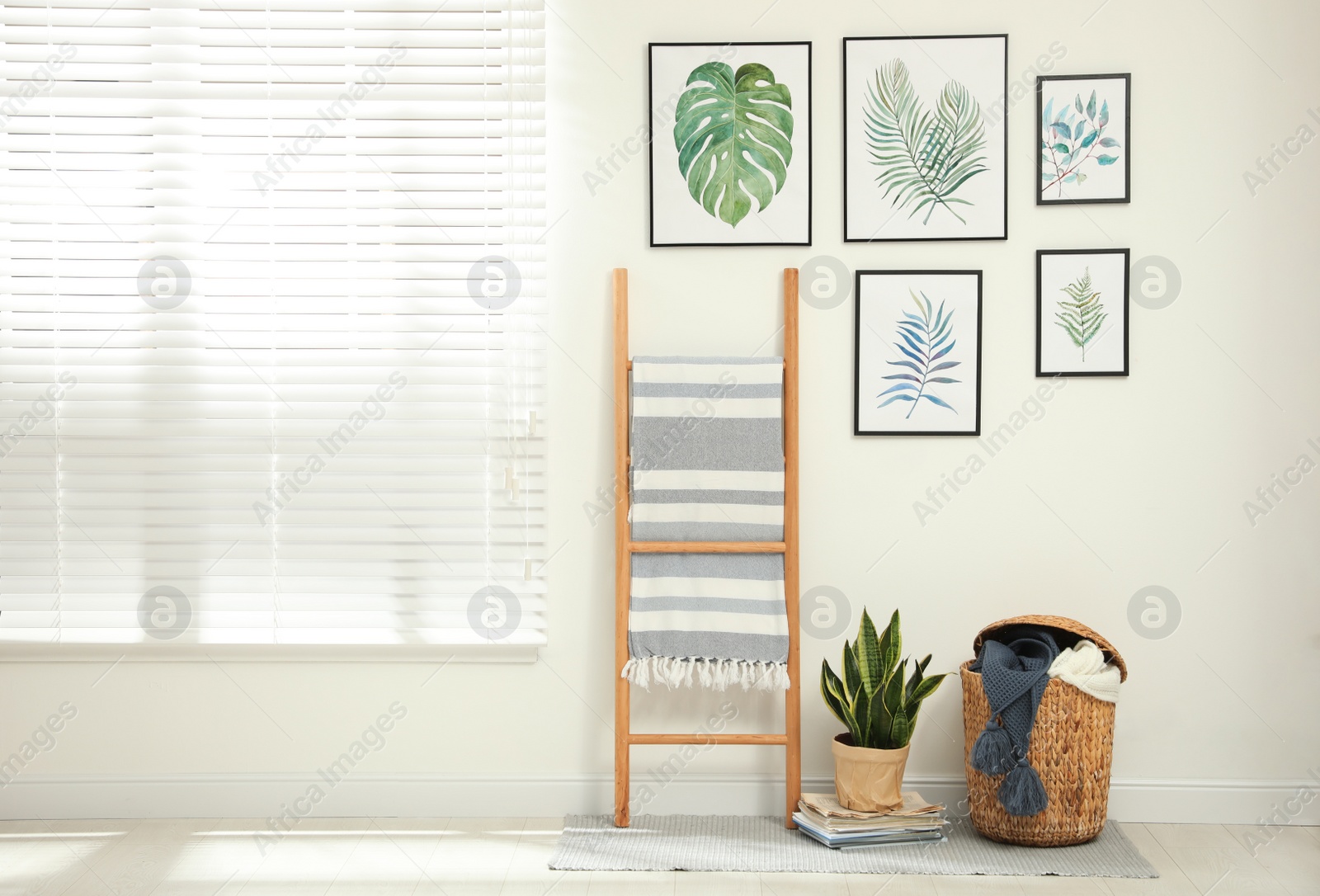 Photo of Beautiful paintings of tropical leaves on white wall in room interior