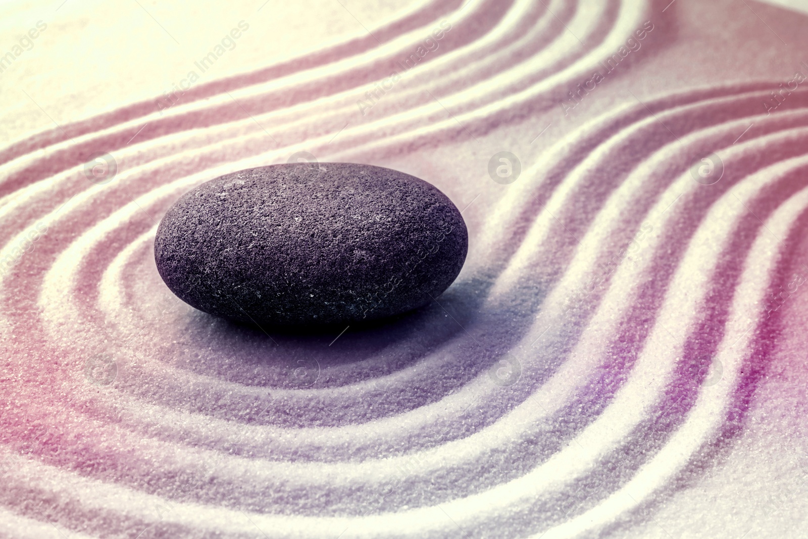 Image of Grey stone on sand with pattern. Zen, meditation, harmony