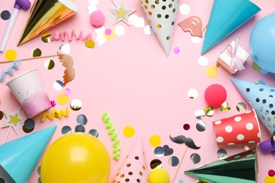 Photo of Frame of party hats and other festive items on pink background, flat lay with space for text. Birthday surprise