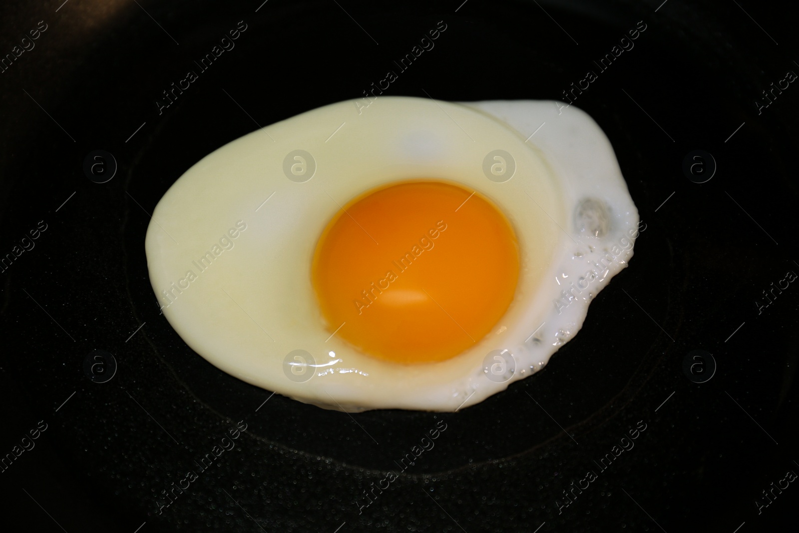 Photo of Cooking egg for tasty breakfast in frying pan, closeup
