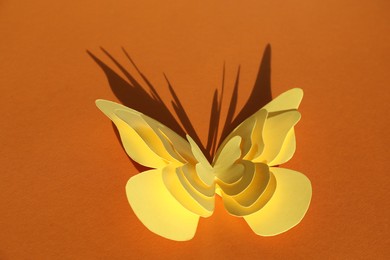 Photo of Yellow decorative paper butterflies on orange background