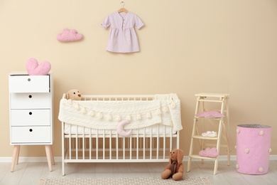 Photo of Stylish baby room interior with comfortable crib