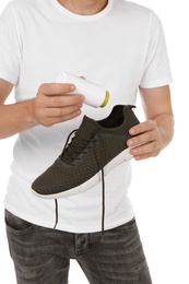 Man putting powder freshener into shoe on white background