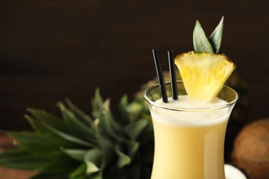 Photo of Tasty Pina Colada cocktail in glass, closeup. Space for text