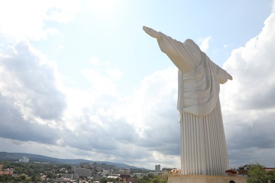 Photo of Truskavets, Ukraine - July 22, 2023: Statue of Christ the Redeemer against beautiful cityscape, space for text