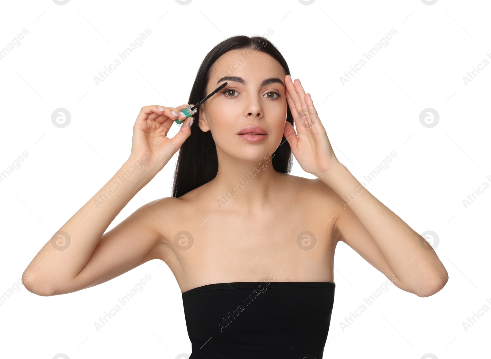 Photo of Beautiful young woman applying mascara on white background