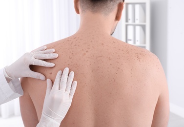 Photo of Doctor examining patient in clinic. Visiting dermatologist