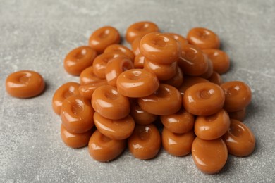 Photo of Tasty hard toffee candies on light grey table, closeup